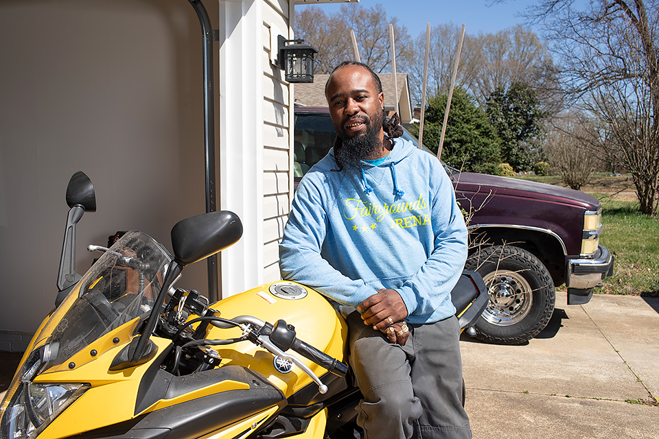 Demetre at his new home, with outdoor space and plenty of parking for his motorcycle.