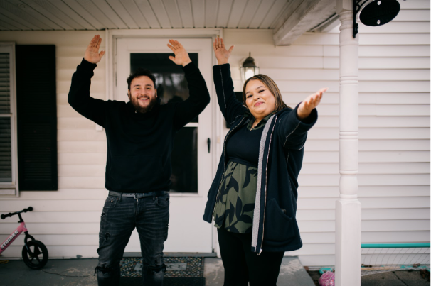 Self-Help borrowers, Dominic and Marisela, celebrate in front of their new house