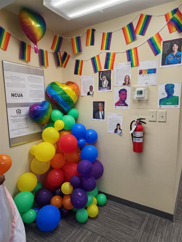 colorful balloons in an office corner next to images on the wall