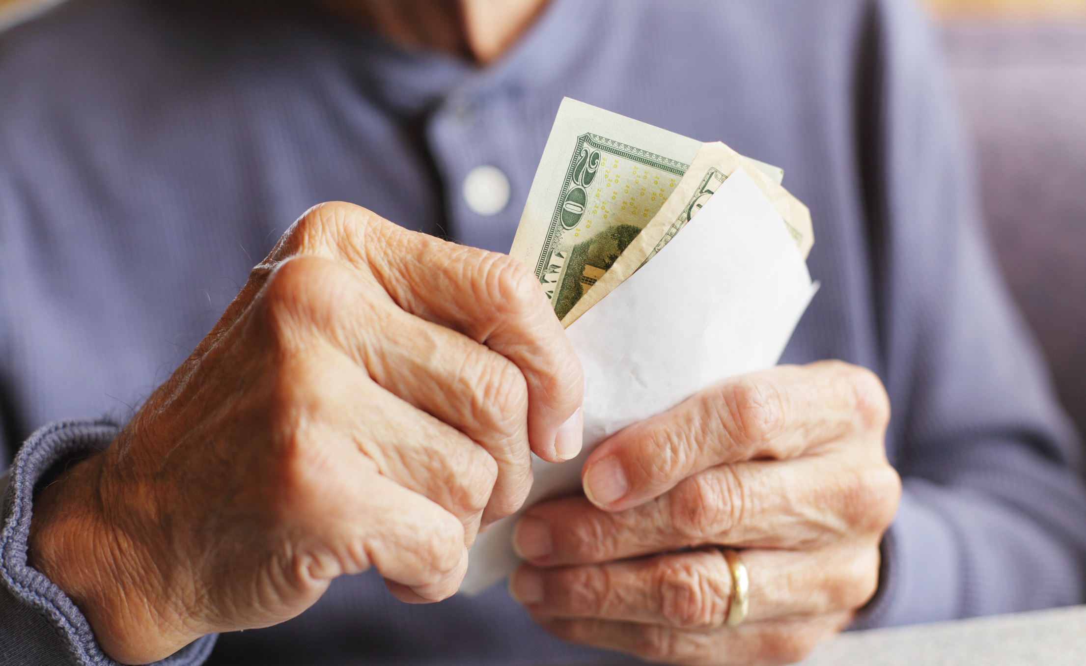 an elderly individual handling cash