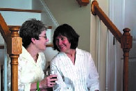 two smiling people sitting at the bottom of a staircase