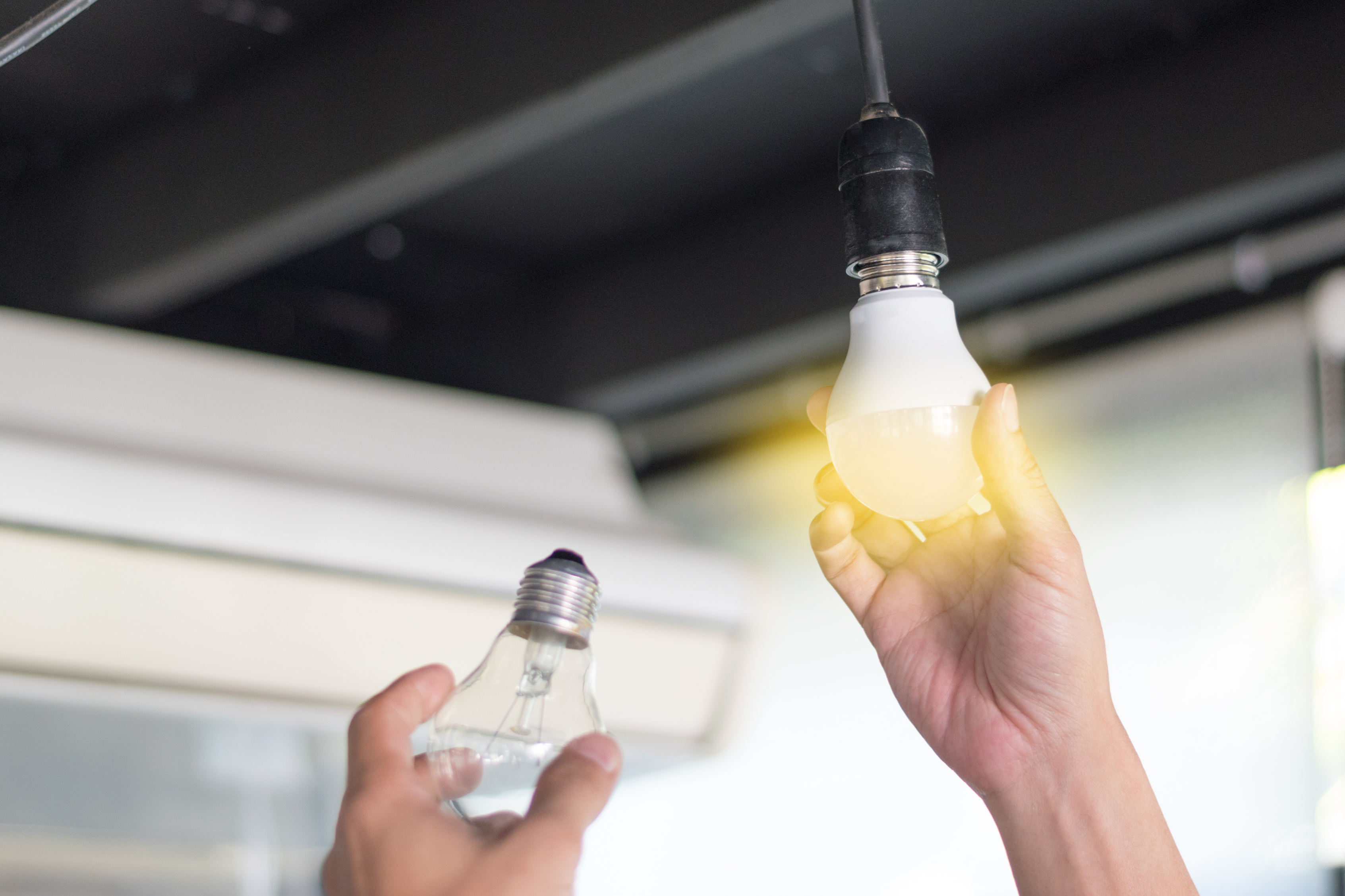 hands changing a light bulb