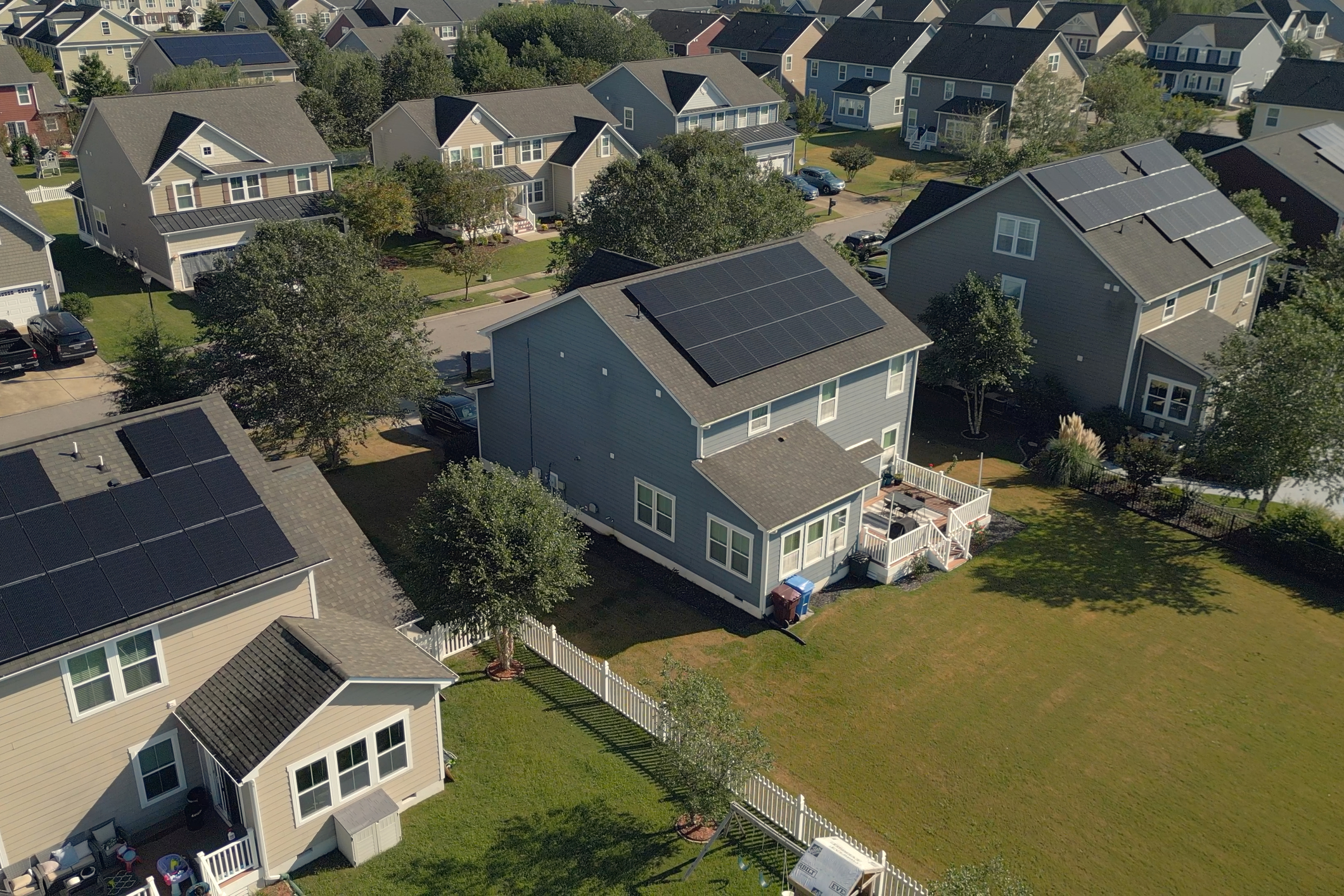 top view of many houses with solar panels on the roofs