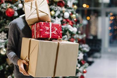 Man holding a stack of gifts