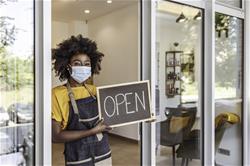 Small business owner with "open" sign