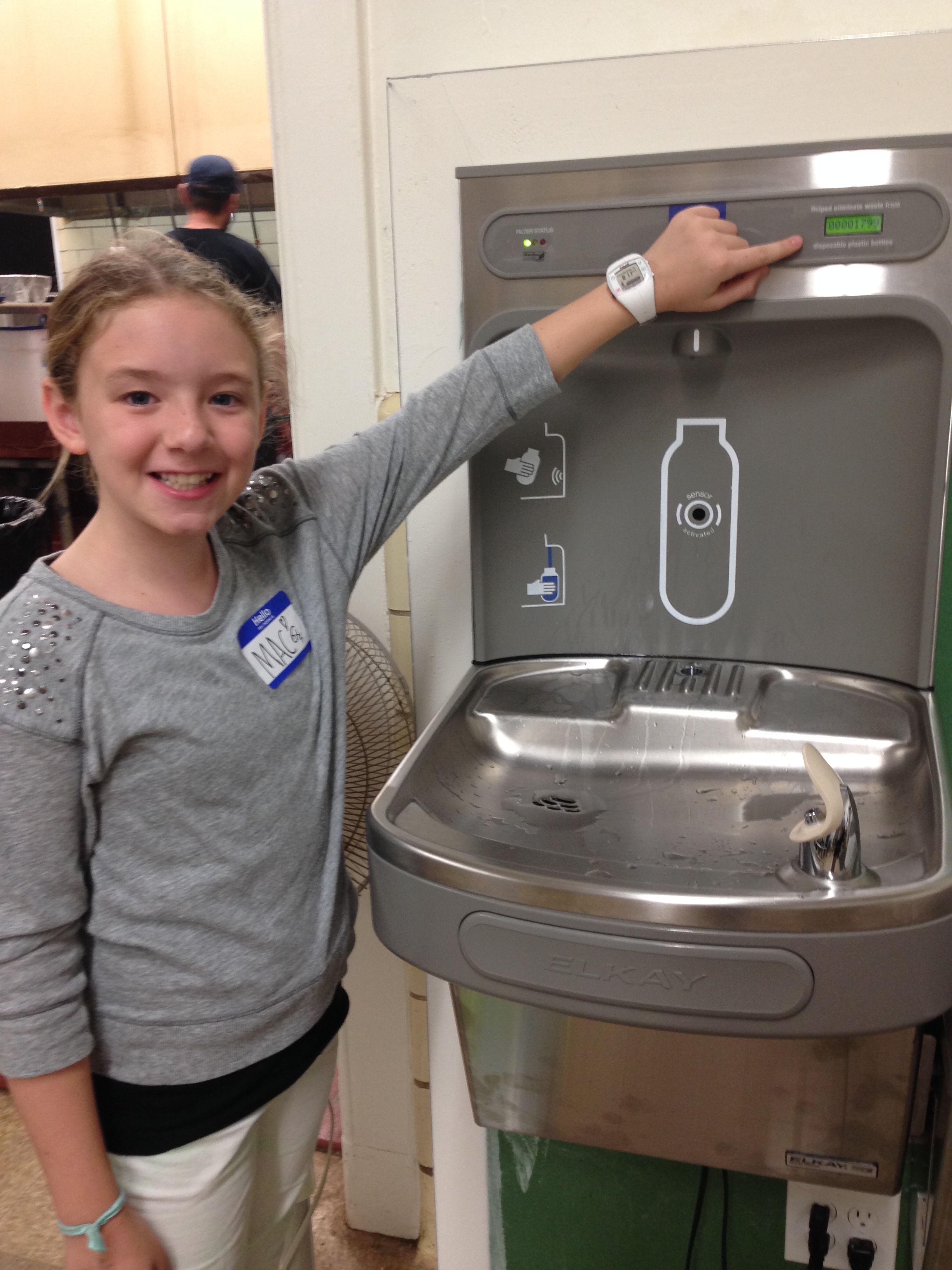 Girl standing next to a water-bottle filling station